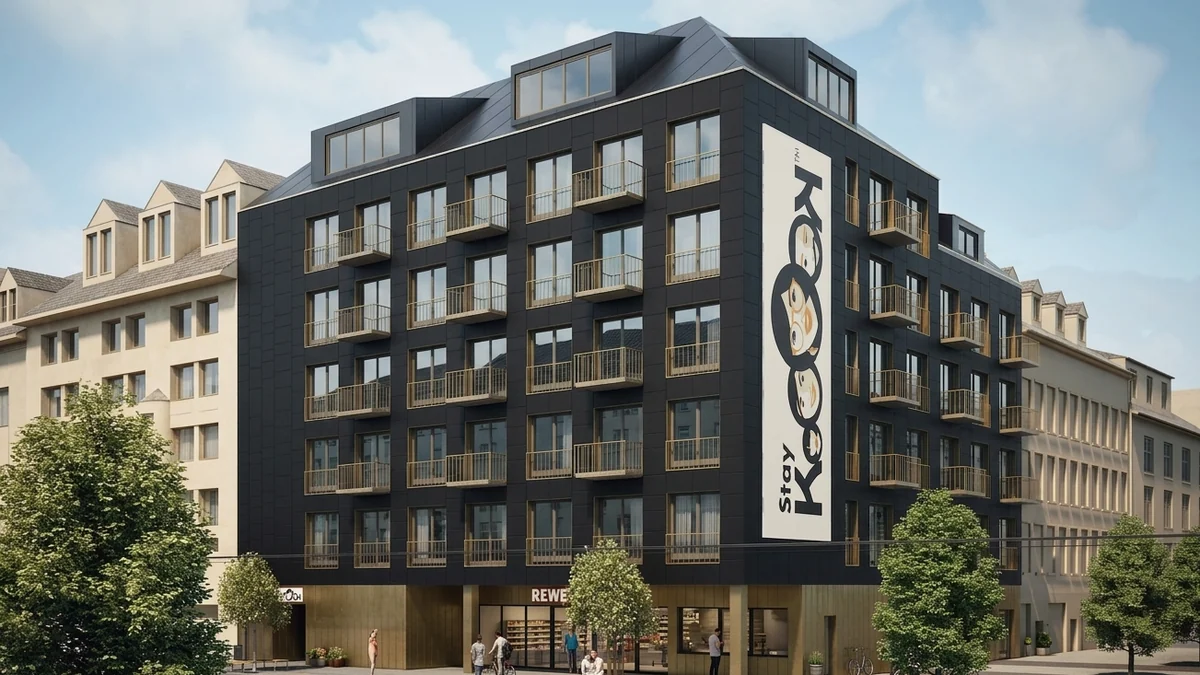 Straßenperspektive des geplanten Hotels mit dunkler Lochfassade und REWE-Markt im Erdgeschoss